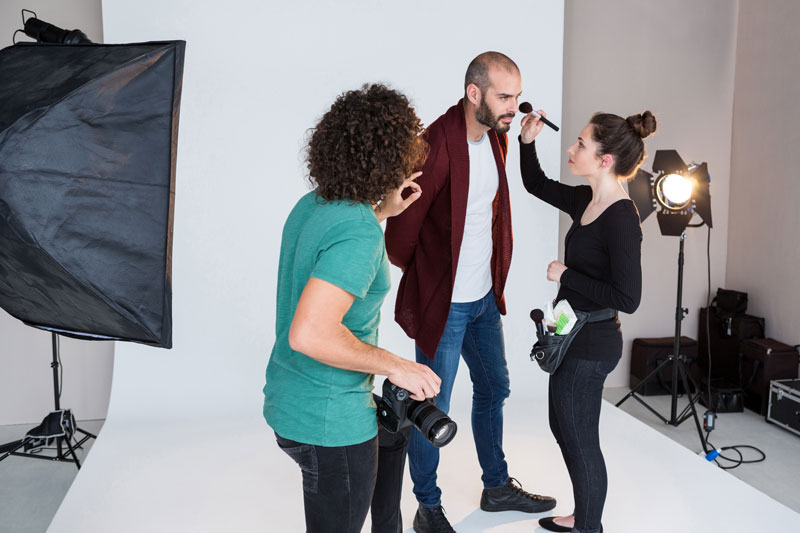Visagist werkt model van Shootz bij die gefotografeerd wordt in de studio