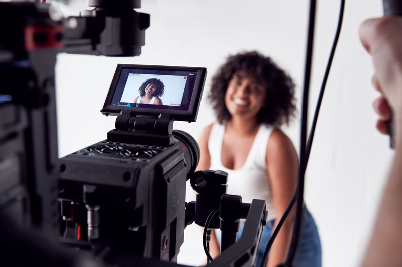Vrouwelijk model van Shootz in studio wordt gefilmd door cameraman